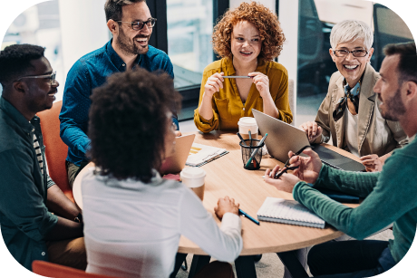 A group of people sitting around a table and smiling