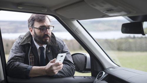 A man with a Microsoft phone in a car