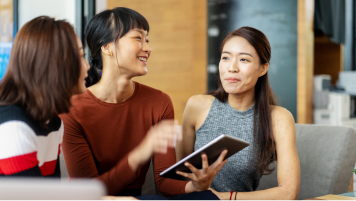 Three people sit to view a presentation