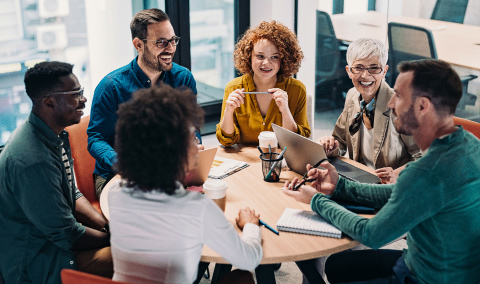 Six coworkers chat around a table