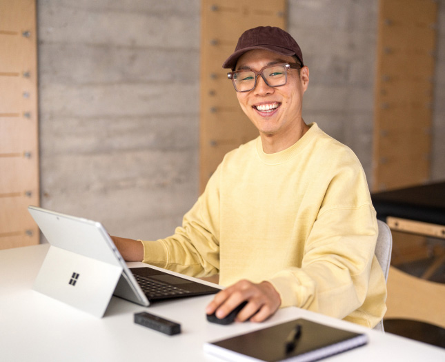 A happy professional works on a laptop