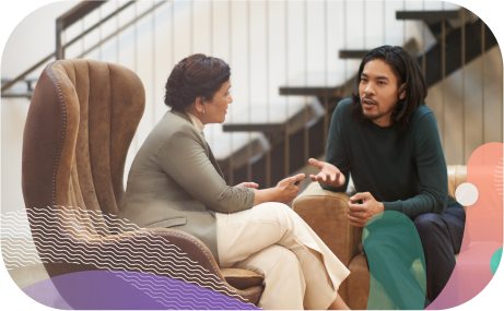 Two people in conversation on office sofas