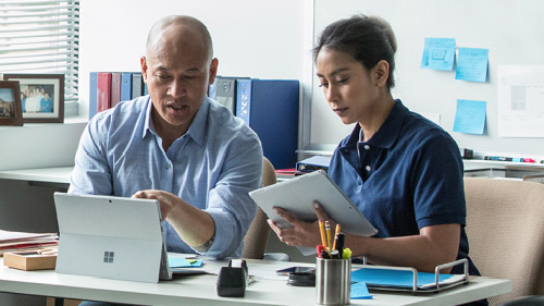 Man and woman collaborating while working inside office