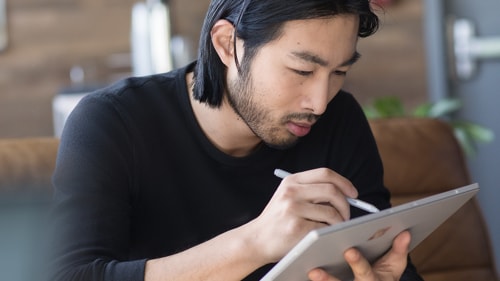 A man works on a design document on his tablet