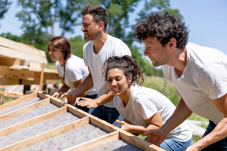 Group of volunteers building a house