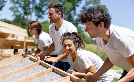 Group of volunteers building a house