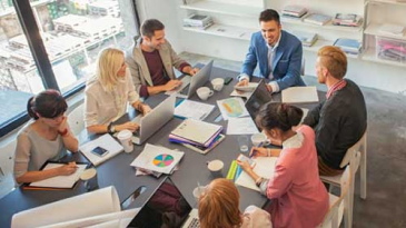 Several people reviewing documentation in a conference room