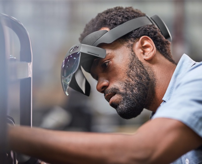 Man wearing an AR headset working on a machine