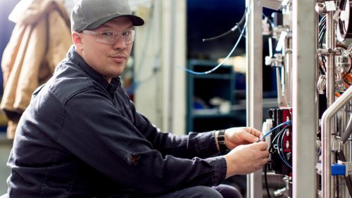 Person wearing safety glasses working on a machine