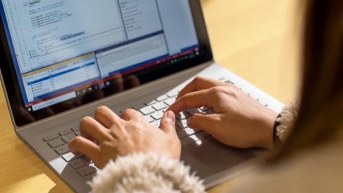 Hands typing on a Surface PC