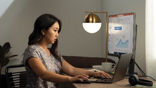 Person sitting at home desk working on a laptop