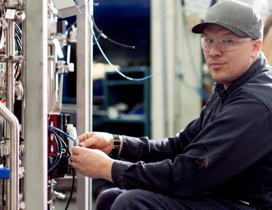 Technician wearing safety glasses working on a machine