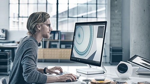 Image of a man working at a Surface Studio