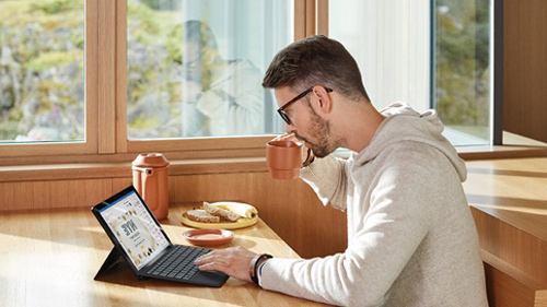 Person working on laptop over breakfast