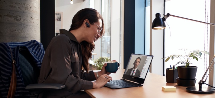 Woman drinking from a mug talking on a video call
