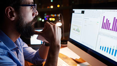 Man viewing data charts on monitor