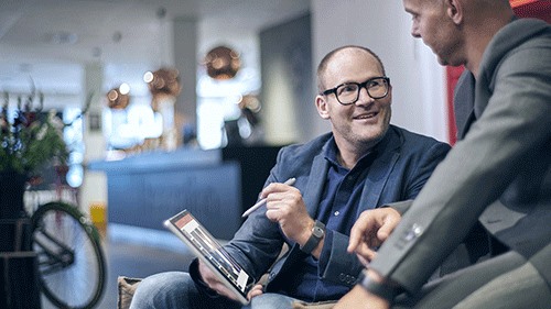 Two coworkers using pen working on tablet