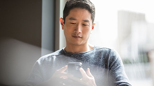 Man looking at and working on mobile device