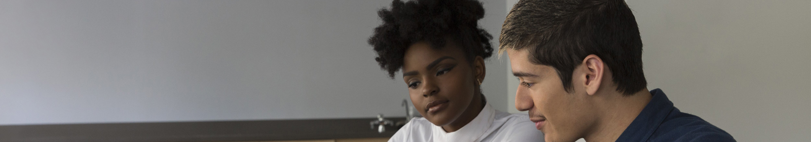 Man and woman with grey background looking down