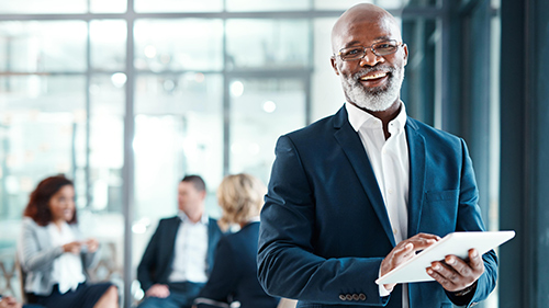 Man standing with Tablet, people in background